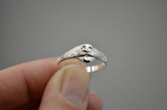 Dog Ring in sterling silver. features a dog nose and mouth with its tongue out. Being held in fingertips.