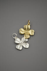 Gold and Silver Four Leaf Clover Charms on gray background
