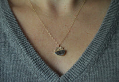 Gold shooting star and boulder opal pendant shown worn with gray sweater