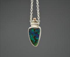 Necklace with a very colorful Australian boulder opal with blues and greens in it. Rose gold dot detail on top. On a silver chain