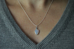Australian Opal and blue Montana sapphire pendant shown worn on model with gray sweater on