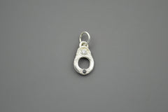 Silver pendant with a white and black diamonds on a gray background