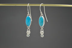 Sterling Silver Oval Turquoise dangle earrings with Montana sapphires set in stars on the bottom