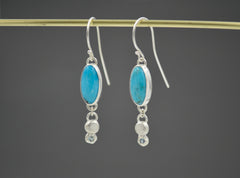 Sterling Silver Oval Turquoise dangle earrings with Montana sapphires set in stars on the bottom