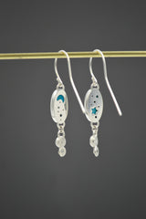 Sterling Silver Oval Turquoise dangle earrings with Montana sapphires set in stars on the bottom. Back shown with moon and stars cut outs