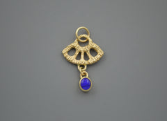 Gold textured fan shape charm with a dark blue opal dangling from the bottom