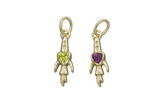 Two gold rocket ship pendants with gemstones on a gray background