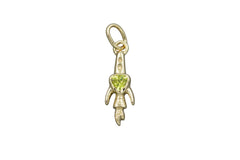 Gold rocket ship pendant with a green trillion gemstone on a gray background