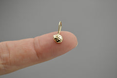 14k gold ladybug pendant on a fingertip to show size