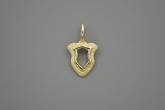 Gold shield pendant on a gray background