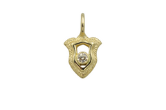 Gold shield pendant with a central champagne diamond on a white background