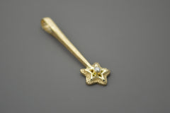 14k yellow gold star wand shaped pendant with a white diamond in the center of the star. Side view.
