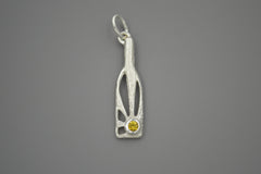 Silver bottle shaped pendant with sunrays within and bright yellow gemstone.