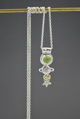 Celestial necklace with stars and planet shapes in silver and gold and a green peridot gemstone.