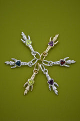Set of silver and gold rocket ship charms with trillion gemstones on a green background