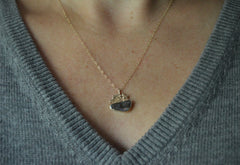 Gold shooting star and boulder opal pendant shown worn with gray sweater