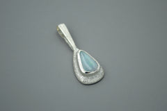 Teardrop-shaped wand pendant with a boulder opal gemstone on a gray background