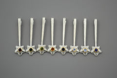 Silver and 14K Star Wand Pendants on a gray background each with a different colored gemstone.