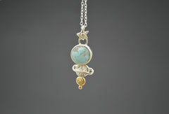 celestial pendant necklace with round blue turquoise, mixed metal dot planets and star shaped bail. On a silver chain.