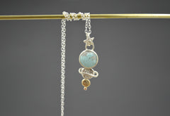 celestial pendant necklace with round blue turquoise, mixed metal dot planets and star shaped bail. On a silver chain.