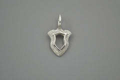 Silver shield pendant on a gray background