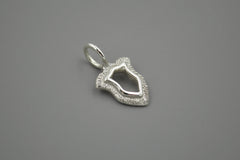 Silver shield pendant on a gray background