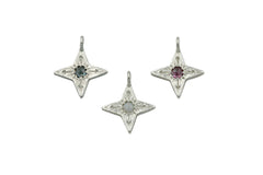 Three silver compass star shaped pendants. The left has a blue Montana sapphire, center has a white Australian opal and right has a berry colored rhodolite garnet.