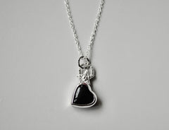 A black onyx heart with a star on top of it and a textured bail. Necklace is sterling silver.