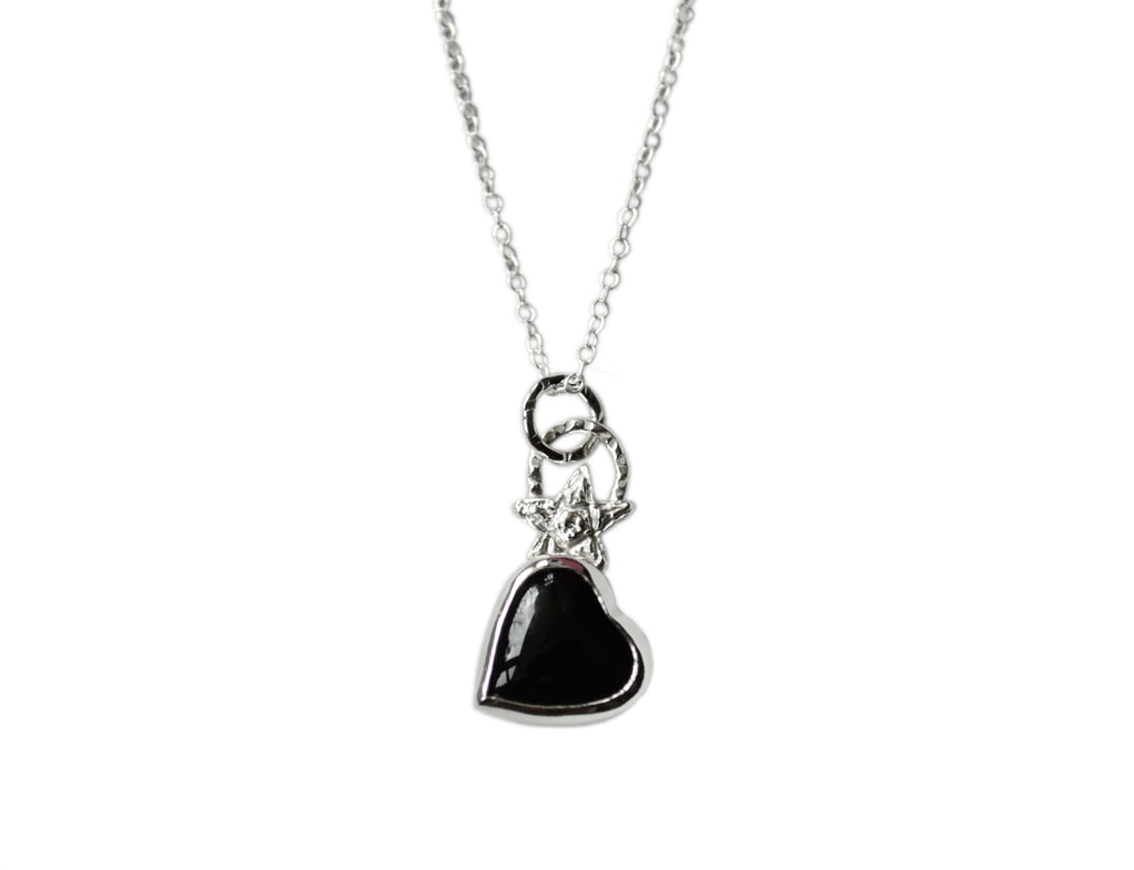 A black onyx heart with a star on top of it and a textured bail. Necklace is sterling silver.