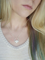 Silver sun necklace on model
