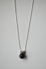 black onyx sphere hangs from a star encrusted pendant on a sterling silver chain.